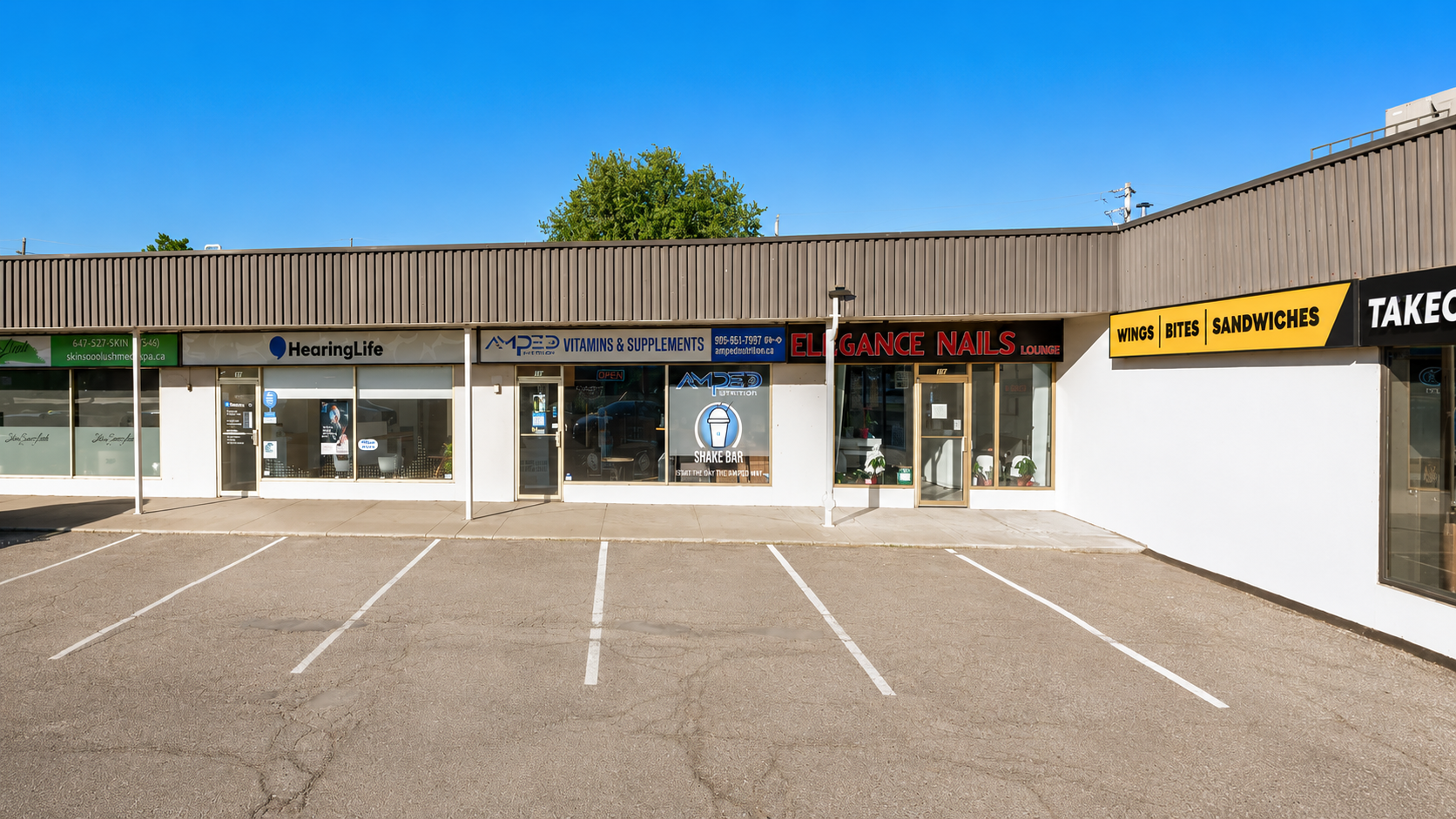 The salon storefront at the plaza with parking and neighboring shops